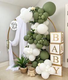 a baby shower with balloons and greenery