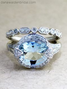 a ring with an aqua blue topazte surrounded by white gold and diamond accents