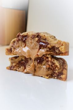 two chocolate chip cookies stacked on top of each other with caramel drizzle