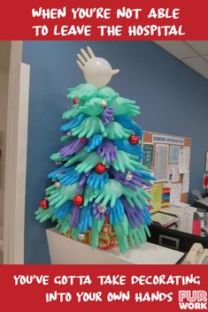 a christmas tree made out of plastic gloves on top of a desk in an office