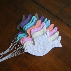 a bunch of clay fish sitting on top of a wooden table next to a whisk