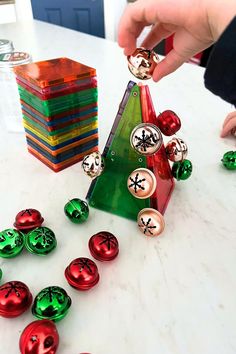 a person placing christmas ornaments on top of a table