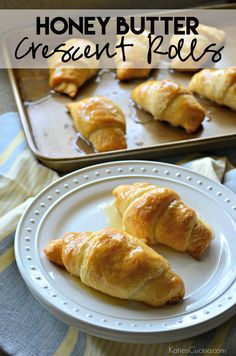 honey butter croissant rolls on a white plate next to a baking pan filled with them