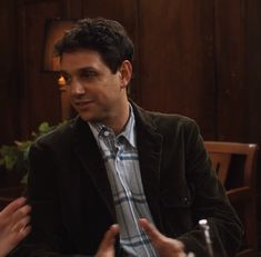 two men sitting at a table talking to each other