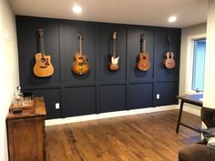 the guitars are hanging on the wall in the room