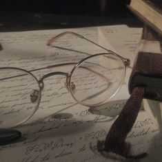 a pair of glasses sitting on top of an open book