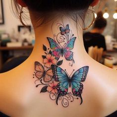 a woman's back neck with colorful butterflies on her upper and lower side tattoos