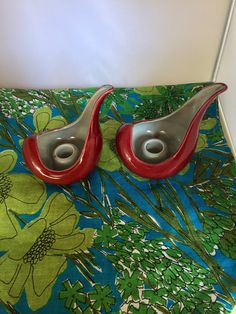 pair of red and silver bird shaped salt and pepper shakers on green floral fabric