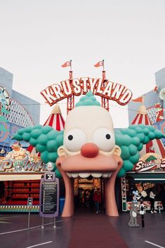 the entrance to an amusement park with a large cartoon character on it's face