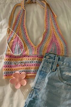 a crocheted top and jean shorts on a bed