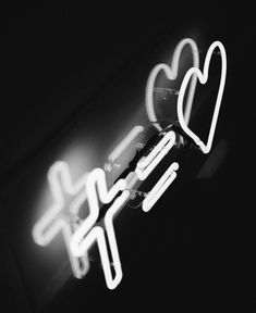 a neon sign with two heart shaped lights on it's side in black and white