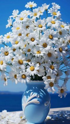 a blue vase filled with lots of white flowers