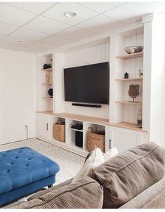 a large flat screen tv mounted to the wall in a living room next to a blue couch