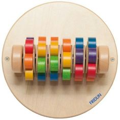 a wooden toy with multicolored spools of tape on top of it