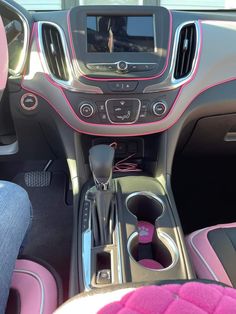 the interior of a car with pink trims and steering wheel controls, including an entertainment center