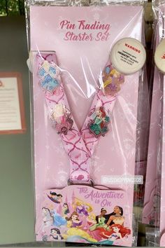 there is a pink ribbon with princesses on it and other items in the package