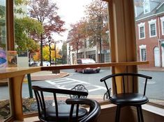 two chairs are sitting in front of a window looking out at the street and cars