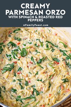 a pot filled with pasta and spinach on top of a table