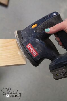 a person using a power tool on a piece of wood