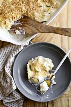 a plate with mashed potatoes and gravy on it next to a casserole dish