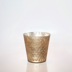 a metal cup sitting on top of a white table