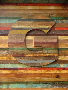 the letter c is made out of multicolored wood