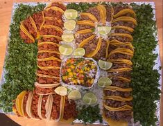 a large platter filled with tacos and other foods