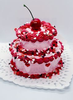 a three tiered cake with cherries and hearts on the top is decorated like a cherry