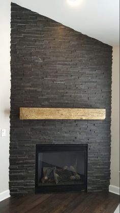 a fireplace with a brick wall and wooden mantle