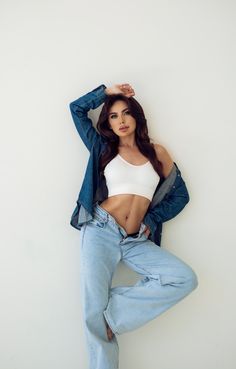 a woman posing in jeans and a crop top