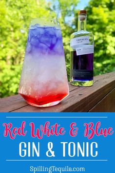 red, white and blue gin and tonic cocktail in a glass next to a bottle