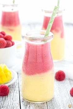 raspberry and pineapple smoothie in a jar with two strawberries on the side