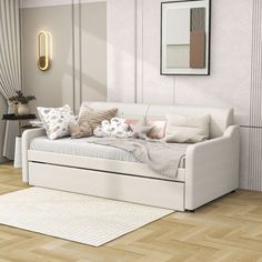 a white day bed sitting on top of a hard wood floor next to a window