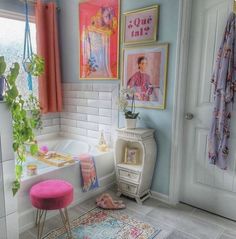 a bathroom with pink stools and pictures on the wall