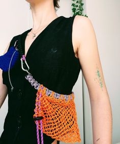 a woman wearing an orange and purple crochet purse