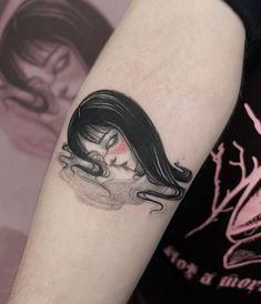 a woman's arm with a black and white tattoo design on the left forearm