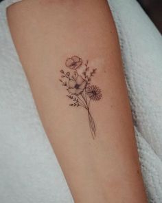 a small flower tattoo on the arm