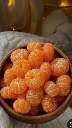 a bowl filled with oranges sitting on top of a table