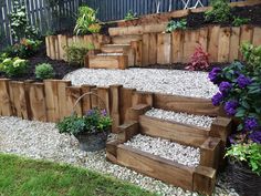 wooden steps are lined with plants and gravel