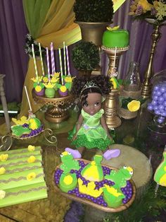 a table topped with cakes and cupcakes covered in green frosting