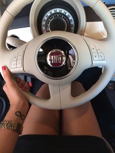 a woman is sitting behind the wheel of a car with her hands on the steering wheel