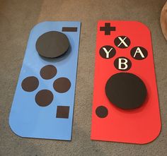 two pieces of paper cut out to look like video game controllers on the floor with buttons