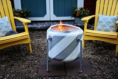 two yellow chairs sitting in front of a fire pit