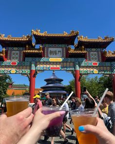 two people holding drinks in front of an archway