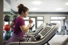 a woman running on a treadmill in a gym