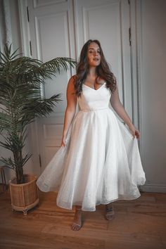 a woman in a white dress posing for the camera