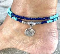 This eye catching beach ankle bracelet is made with light blue glass beads, pale mint glass beads, navy blue glass beads, silver tibetian beads, and a silver plated sand dollar charm. Ankle Bracelet comes in several sizes, just choose your size from the drop down menu at checkout. Blue Beaded Ocean-inspired Anklet, Ocean-inspired Blue Beaded Anklet, Adjustable Blue Anklets For Beach, Handmade Blue Beachy Anklets, Blue Beachy Anklets For Gift, Handmade Blue Anklets For Beach Season, Blue Ocean-inspired Anklets For Summer, Turquoise Round Beads Anklets For Beach, Turquoise Beaded Strand Anklets