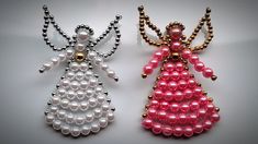 two beaded angel brooches sitting next to each other