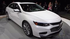 a white car is on display at an auto show