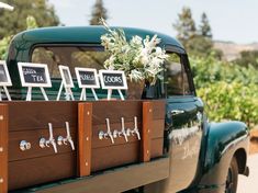 an old green truck with wooden boxes on the back